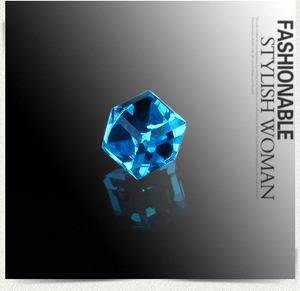 Detailed macro shot of blue crystal cube magnetic earrings on a reflective black surface
