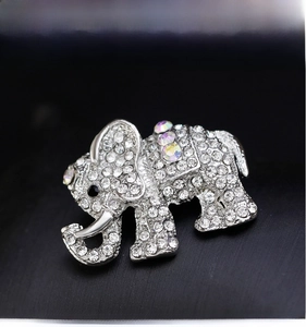 Detail shot of silver elephant brooch with sparkling rhinestones on black background