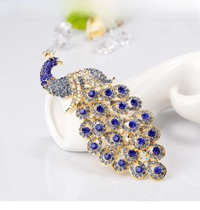 Detailed close-up of peacock brooch with royal blue crystals and gold-plated alloy