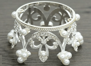 Close-up of silver bridal crown with crystal fleur-de-lis patterns and white pearls