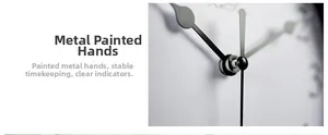 Detail of sleek black metal hands on a silent wall clock with a minimalist white dial
