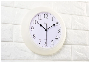 Detail of creative wall clock with clear black Arabic numerals and white plastic frame