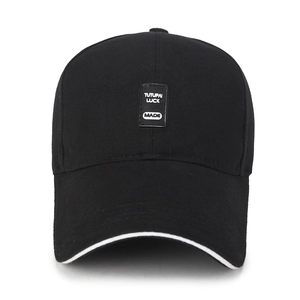 Classic black cotton baseball cap with white trim and Tutupai Luck patch on the front