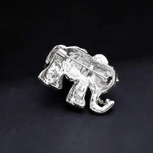Back view of silver elephant brooch showing metal texture and secure safety pin clasp