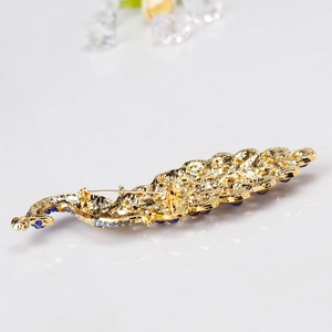 Peacock brooch with royal blue crystals and gold base shown from a detailed back view