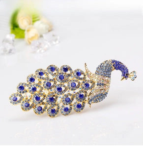Detail of royal blue crystal peacock brooch with intricate rhinestone inlay on gold base