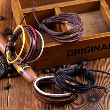 Detail of bohemian handmade woven braided leather bracelets on vintage wooden surface