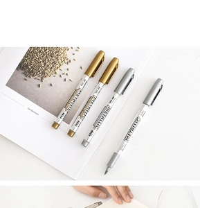 Detailed macro view of MP550 gold and silver metallic craft pens on a white desk