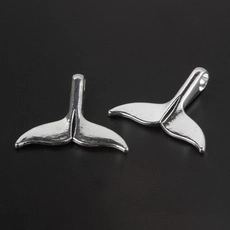 Close-up of silver whale tail pendants with polished finish for DIY jewelry crafts