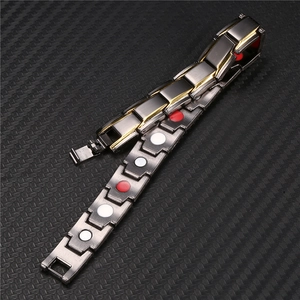 Macro view of black and gold healthcare bracelet featuring magnetic therapy elements