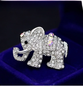 Macro shot of silver elephant brooch with rhinestones on a blue velvet jewelry box