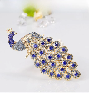 Macro detail of royal blue crystal peacock brooch with gold-tone rhinestone tail feathers