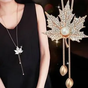 Detail of maple leaf pendant with rhinestones, pearl accent and long tassels