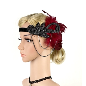 Detail of red feather fascinator with black velvet band and shimmering rhinestone chains