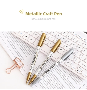 Close-up of Baoke metallic craft pens in gold, silver and bronze on a workspace
