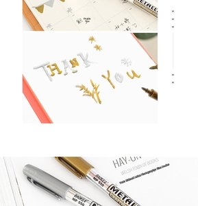 Macro detail of metallic gold and silver markers on a journal with fine nib close-up
