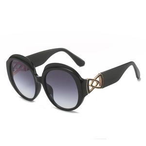 Occhiali da sole rotondi retrò oversize da donna con montatura nera e lenti sfumate viola