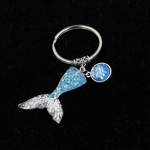 Exquisite mermaid tail keychain with gradient scales and silver alloy clasp on black velvet