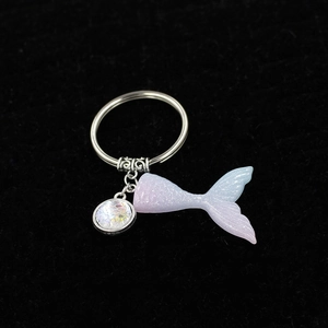 Detail of mermaid tail keychain with gradient resin finish and shimmering fish scale charm