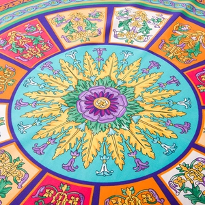 Detail of colorful floral silk scarf showing purple roses and classic scroll patterns