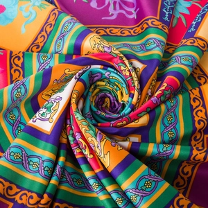 Detail of silk-like satin scarf featuring intricate baroque floral patterns in gold and purple