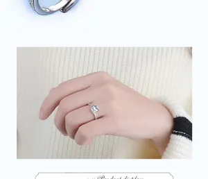 Close-up of minimalist silver zircon ring on model finger with elegant knitted background