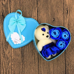Detailed view of heart-shaped tin box with blue soap flowers and a white plush bear