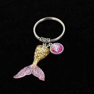 Close-up of a gradient pink mermaid tail keychain with glitter and fish scale charms
