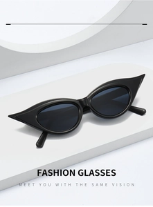 Detail of black cat eye sunglasses with sharp wing tips on a white geometric stage