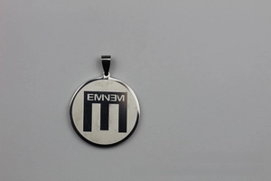 Macro shot of polished silver stainless steel round tag with custom engraved Eminem logo