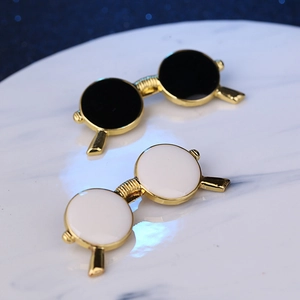 Stylish pair of sunglasses-shaped enamel brooches in black and white with gold trim