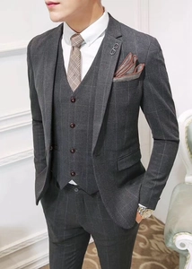 Detail of grey plaid three-piece suit with metal brooch on the blazer lapel