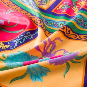 Detailed close-up of premium twill silk scarf with vibrant floral patterns and soft texture