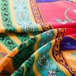 Macro view of floral print satin fabric texture and vibrant colors on large square scarf