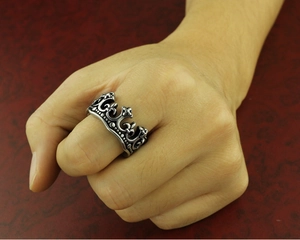 Macro detail of crown shaped stainless steel ring with vintage hollow patterns on a hand