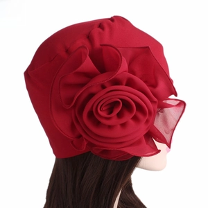 Detail of the oversized burgundy fabric flower on this elegant elastic turban hat
