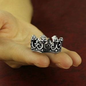 Vintage silver and black crown ring in stainless steel shown in a hand-held view