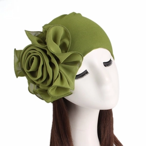 Detail of elegant olive green turban featuring a large 3D fabric rose flower decoration