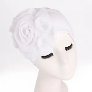 Detail of elegant white turban hat with layered 3D chiffon flower for women