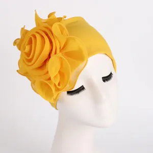 Close-up of elegant yellow stretchy turban hat featuring a large side flower detail for women