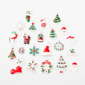 Dettaglio macro di vari ciondoli natalizi in smalto colorato come Babbo Natale per gioielli DIY
