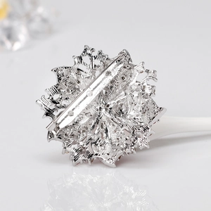 Back view of silver crystal flower brooch showing secure pin and detailed metal texture