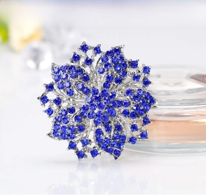 Macro detail of luxury silver brooch with blue crystals on a perfume bottle
