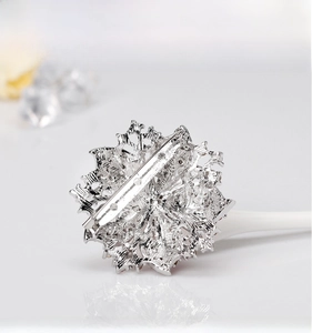 Detailed back view of silver snowflake brooch with secure pin clasp and hollowed texture