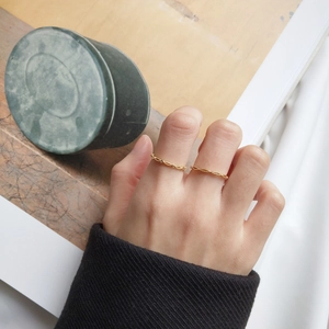 Detail view of two minimalist thin gold plated S925 silver rings with wavy textures