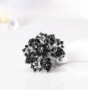 Close-up of luxury flower brooch with black rhinestones and silver metal base