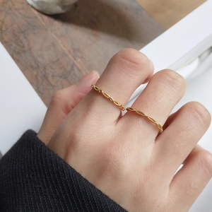 Detail of 18k gold plated S925 silver rings with chain and braided rope designs