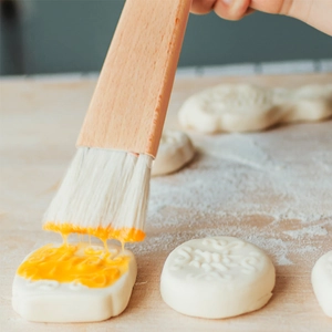 Japanese beech wood pastry brush with boar bristles applying egg wash to dough