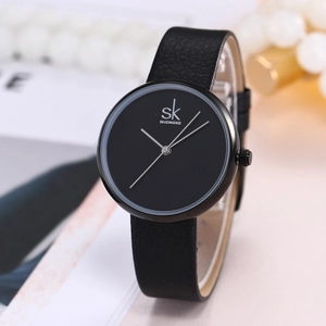 Detail view of a black Shengke quartz watch with leather strap on a decorative background