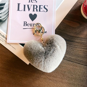 Detail of dark grey heart-shaped faux fur keychain with glossy gold lobster clasp